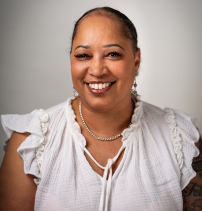 A woman with a white top is smiling.