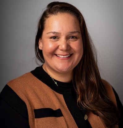 A woman with long hair is smiling.